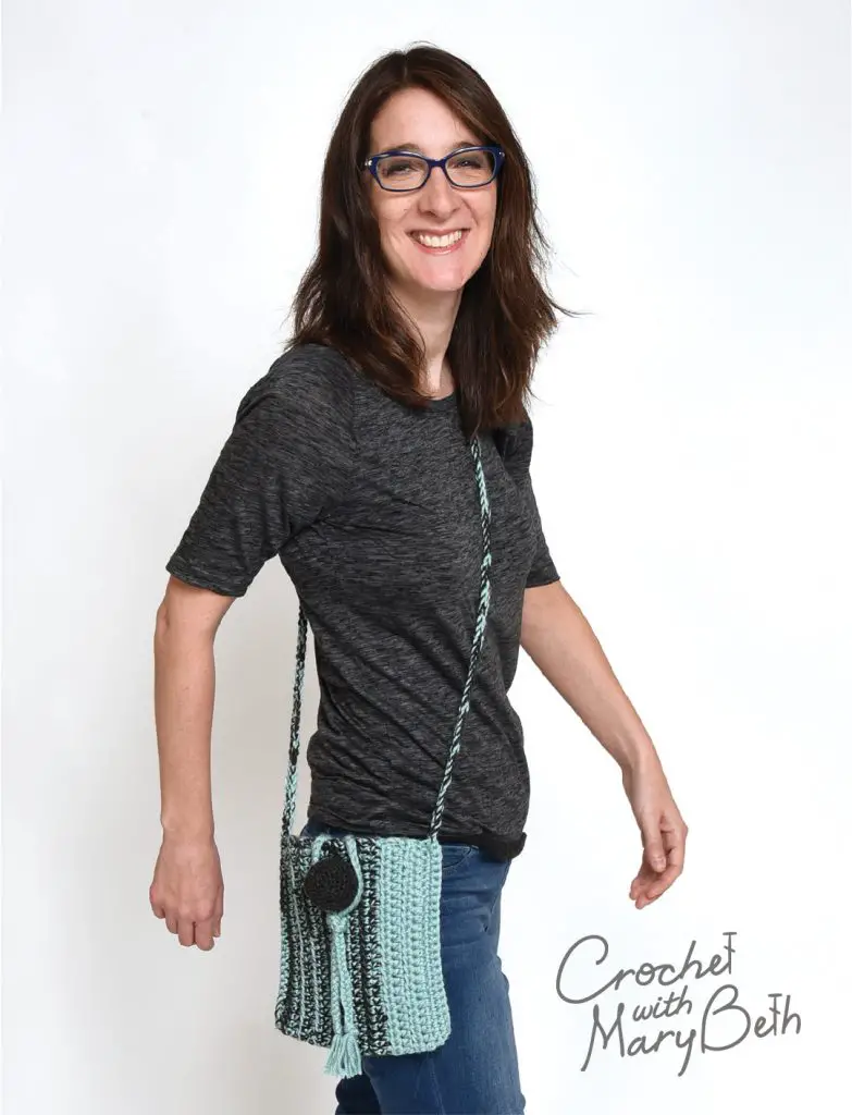 A woman modeling the Ball Button Crossbody Bag.  A free crochet bag pattern that can be found on the website crochet with mary beth.