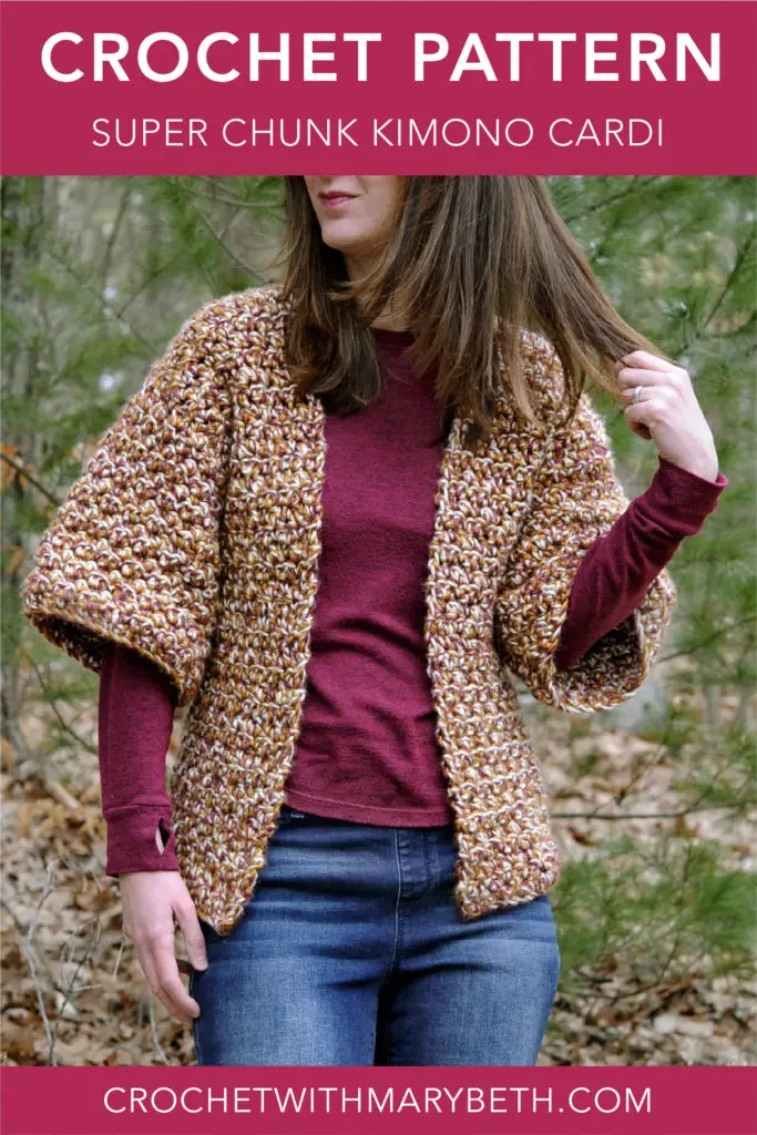 Woman brushing away hair wearing a crochet cardigan.