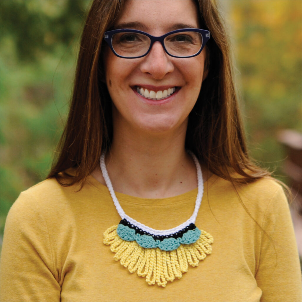 A woman wearing a crochet necklace designed by Crochet with Mary Beth.
