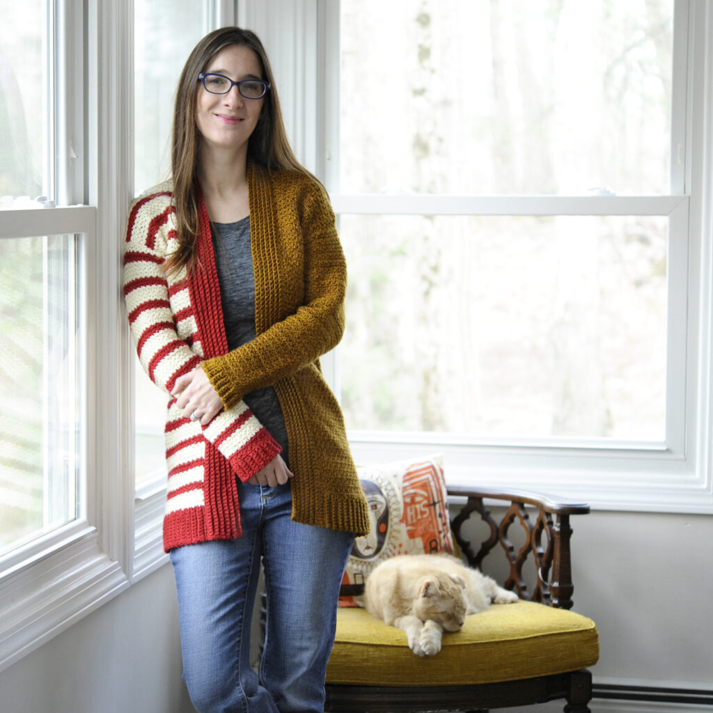 A woman wearing the Stripe Blocked Cardigan.  The cardi is seamed up the side with the mattress stitch.