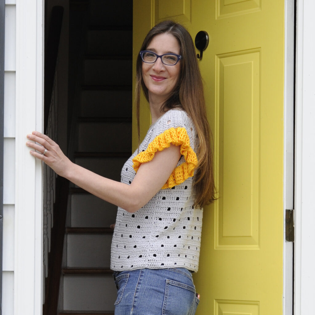 A woman wearing the Be Spotted Tee.  The tee is seamed up the side with the mattress stitch.