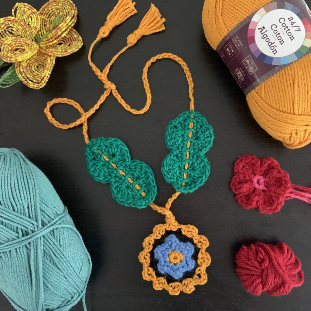 Close up of the Once and Floral Necklace.  This necklace is made with four colors of worsted weight stash yarn.  This crochet project will get your creative juices flowing.