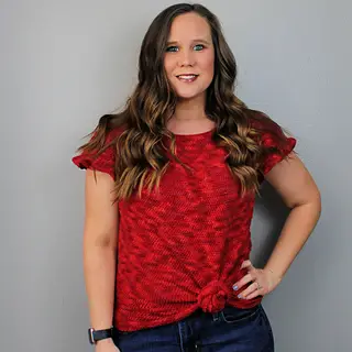 Michelle Ferguson of Two Brothers Blankers wearing a red, knotted, modest crochet top pattern.