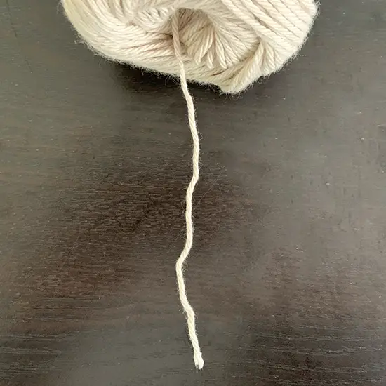 A skein of yarn with a tail pointing down.