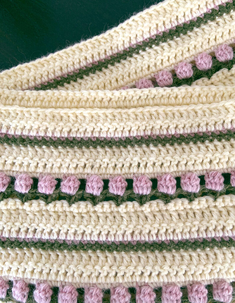A close-up of the tulip stitch on the roses on repeat infinity scarf pattern a crochet pattern for a modern scarf.