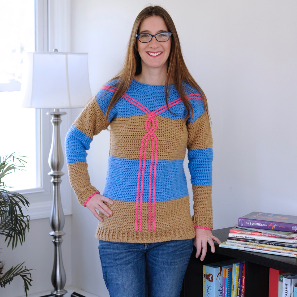A woman wearing the Draw the Line Crochet Sweater Pattern by Mary Beth Cryan.