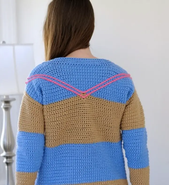 The back of a crochet sweater pattern for adults featuring pink slip-stitch surface crochet.