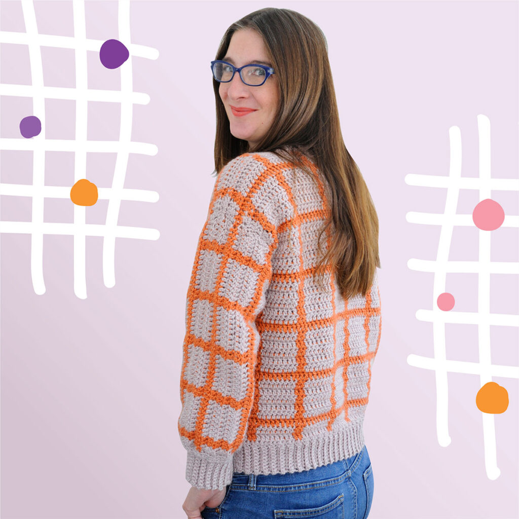 The back of the Fair and Square crochet pattern. The crochet pullover is made in tapestry crochet in orange and purple. It's an easy crochet sweater pattern for women.
