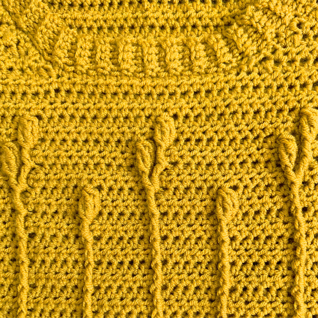 A close-up of the floral cable stitch on the Best Buds Crochet Sweater Pattern, an indie crochet pattern by Mary Beth Cryan.