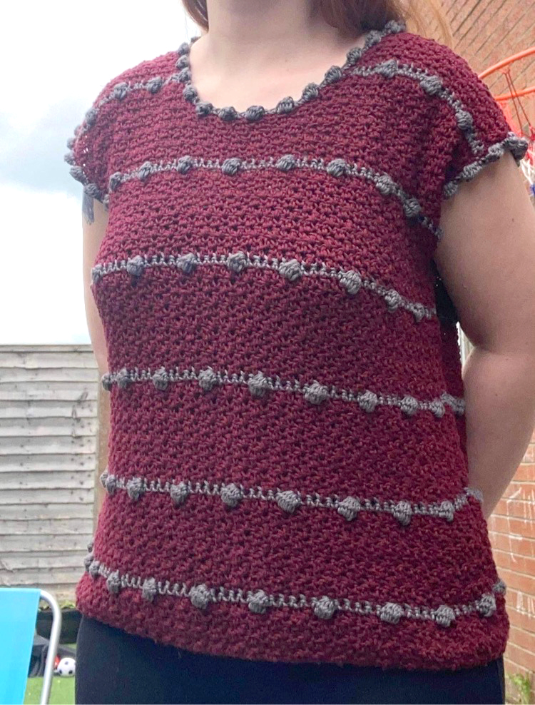 A red and gray crochet top with bobble edging.