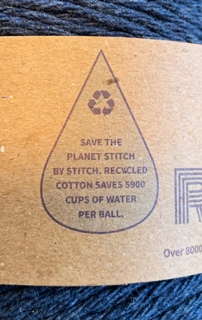 The label from Re-up yarn.  The label reads "save the planet stitch by stitch.  Recycled Cotton Saves 5900 cups of water per ball.