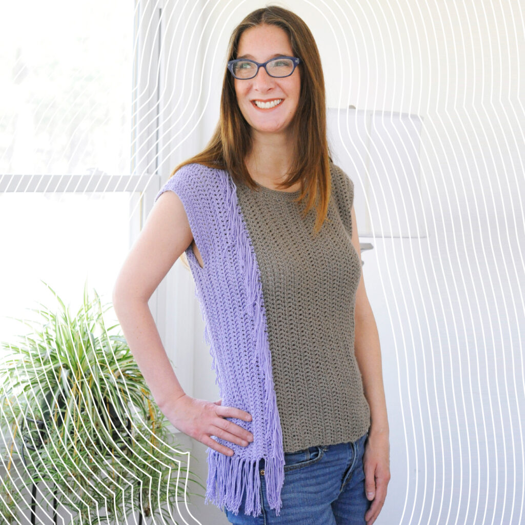 A woman wearing a crochet top.  The top is seamed on the side with a mattress crochet seam.
