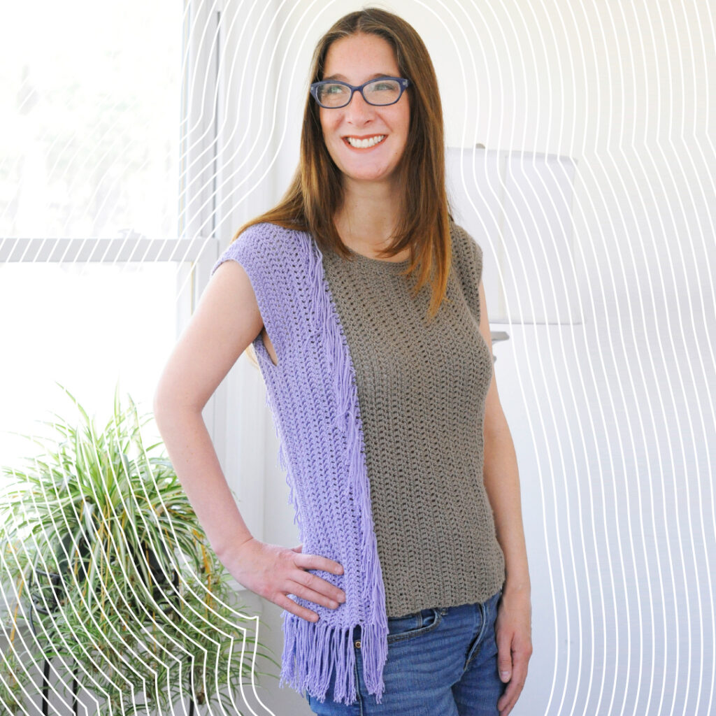 A woman wearing a crochet top. The top is seamed on the side with a mattress crochet seam.