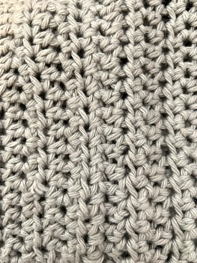 An up close view of a single crochet seam joining two pieces of a crochet garment at the shoulder.