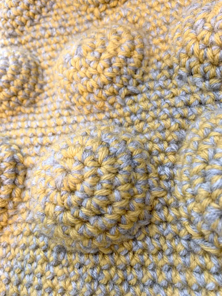 A close-up view of crochet seams on a bag. The seams are stitched with a whip stitch seam.